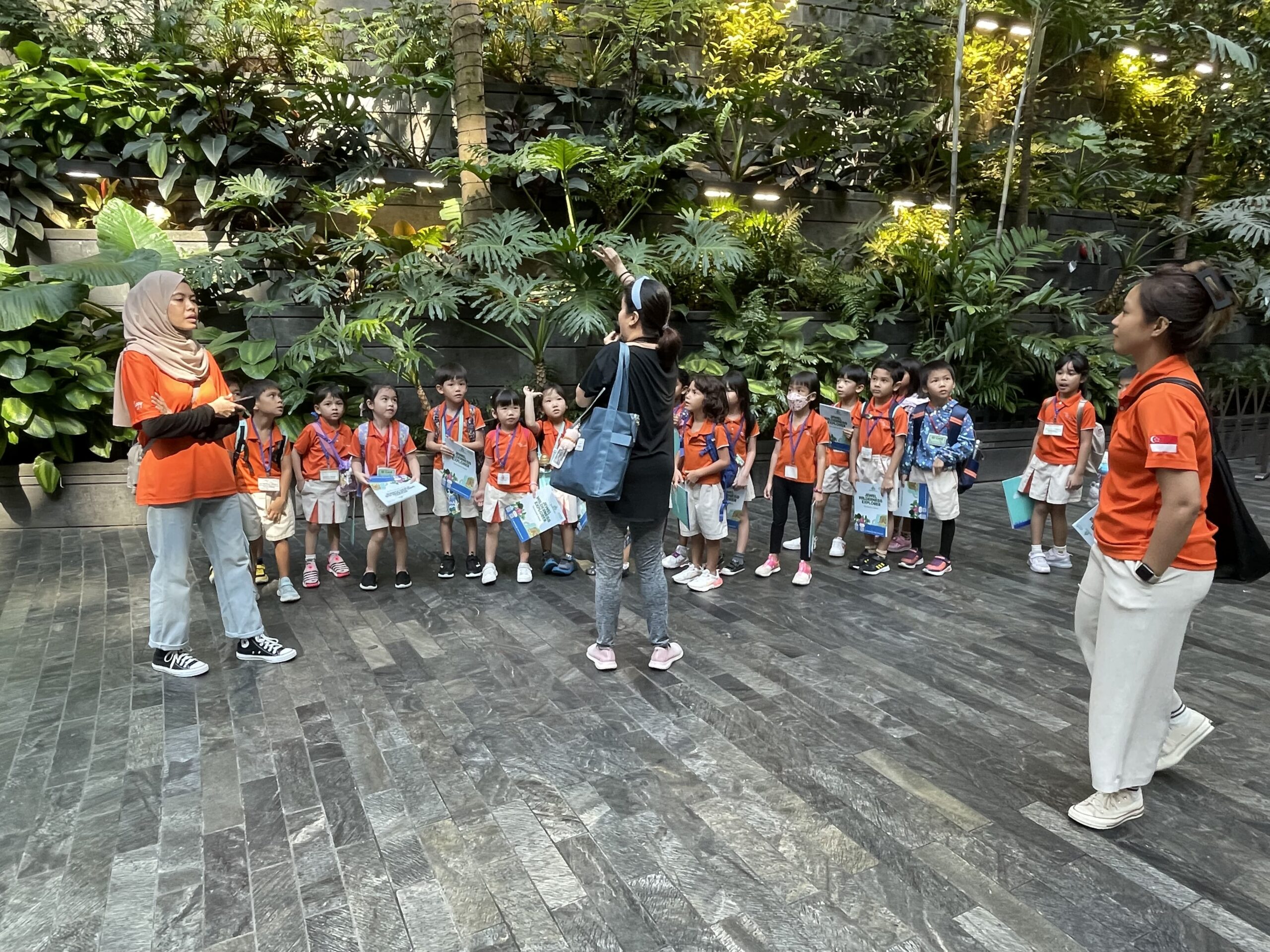 Teacher guiding students during rainforest walk at Jewel