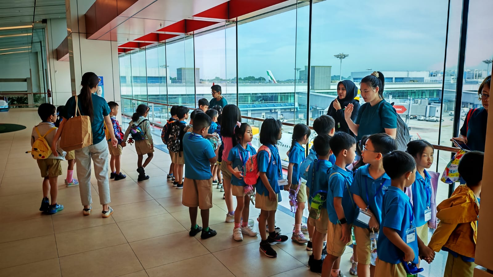 Children and teachers posing in front of the Rain Vortex